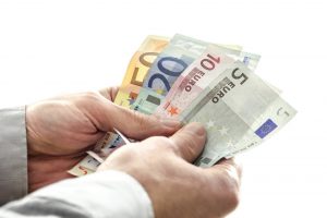 Closeup of a man holding Euro money banknotes. Isolated over white background.