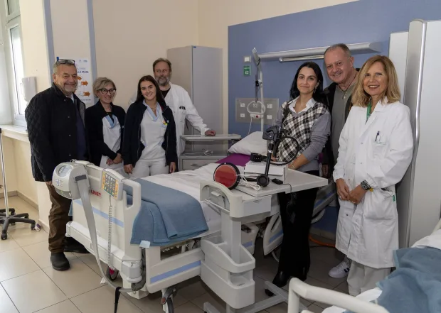 Medici, infermiere e rappresentanti dell'Associazione Io Vivrò in una stanza dell'Ospedale di Imola accanto ai dispositivi di chiamata donati