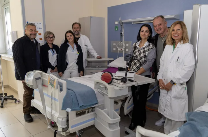 Medici, infermiere e rappresentanti dell'Associazione Io Vivrò in una stanza dell'Ospedale di Imola accanto ai dispositivi di chiamata donati